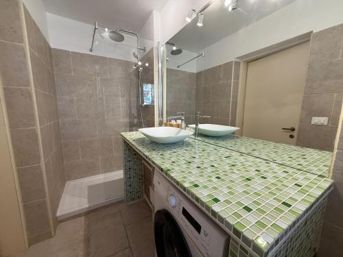 une salle de bain avec deux lavabos et une douche dans l'établissement Le pano, à Beausoleil