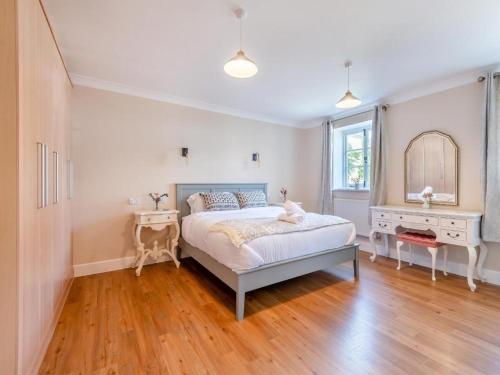 a bedroom with a bed and a table and a mirror at The Annex at Merley Mews in Poole