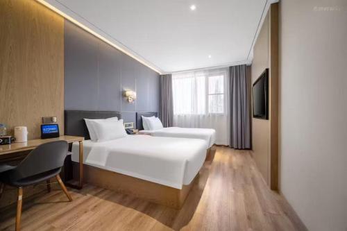 a hotel room with two beds and a desk and a computer at Weiting Hotel Shanghai North Sichuan Road Hongkou Football Stadium Subway Station Branch in Shanghai