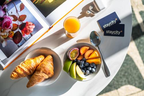 a table with a plate of food and a bowl of fruit at Staycity Aparthotels Dublin Augustine in Dublin