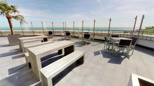 a patio with tables and chairs and a view of the ocean at The View Hotel in Eastbourne