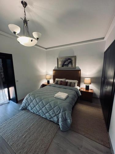 a bedroom with a bed and two lamps and a ceiling at Blue Hope Duplex with sea and mountain views in Taghazout