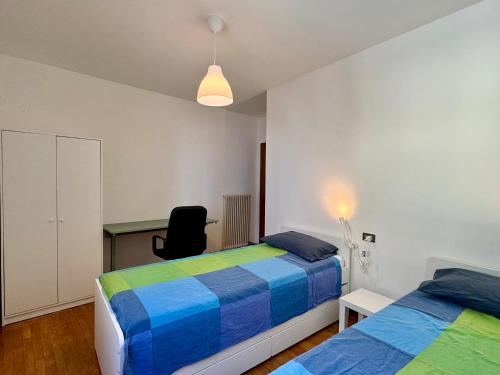 a bedroom with two beds and a desk and a chair at 1Dest - Riva Life in Riva del Garda