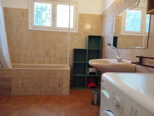 une salle de bain avec une baignoire et un lavabo et une baignoire dans l'établissement Rez de jardin pour ce T3 spacieux proche plage et commerces - 4BERNA1, à Saint Cyprien Plage