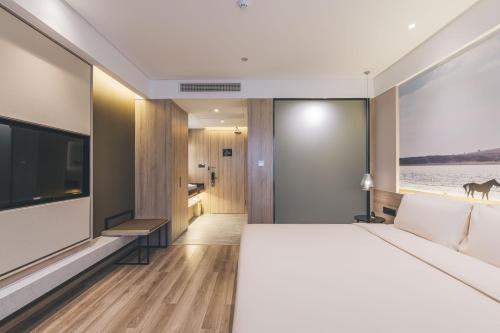a bedroom with a large bed and a television at Atour Hotel Shanghai Anting in Shanghai