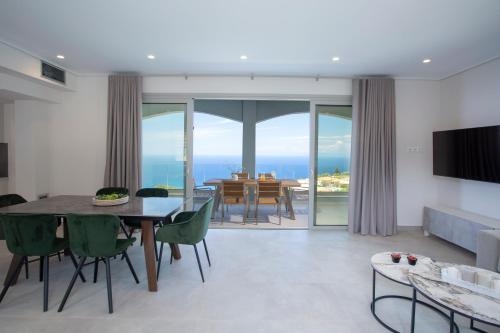 a dining room with a table and chairs and a television at Emilia Villas in Agios Nikitas