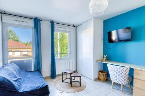 a bedroom with blue walls and a bed and a tv at L'Havre de paix - Vaulx en Velin- Proximité Lyon in Vaulx-en-Velin