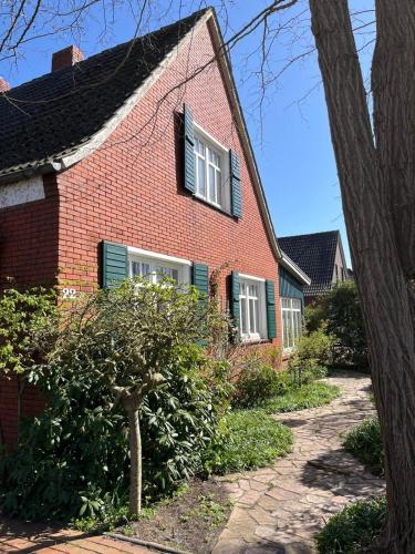 a red brick house with green shuttered windows at Ferienhaus Frerichs 15209 in Leer