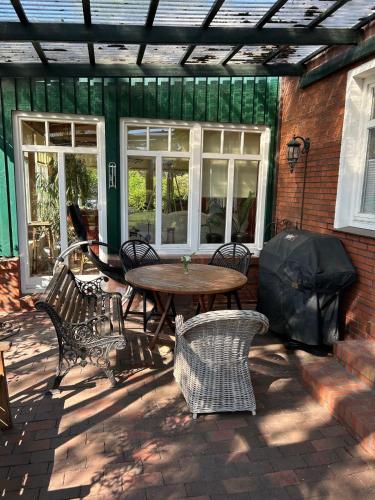 a patio with a wooden table and chairs at Ferienhaus Frerichs 15209 in Leer