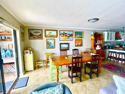 a kitchen and dining room with a wooden table and chairs at Port Owen Marina Point in Velddrif