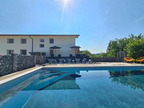 a villa with a swimming pool in front of a building at VILA LISJAK - Apartments in Podčetrtek