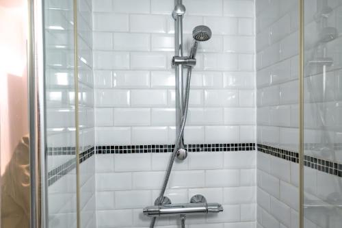une douche dans une salle de bain avec du carrelage blanc dans l'établissement Apt 6 Guests Charme Opera de Paris, à Paris