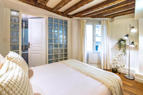 une chambre avec un lit et une fenêtre dans l'établissement Apt 6 Guests Charme Opera de Paris, à Paris