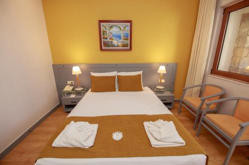 a bedroom with a large bed and two chairs at Orka World Hotel & Aquapark in Oludeniz