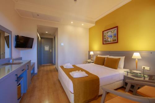 a hotel room with a large bed and a television at Orka World Hotel & Aquapark in Oludeniz