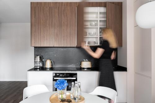 una cucina con una donna nel forno e un tavolo di Scala City Center Apartments with Parking by Lion Apartments a Danzica