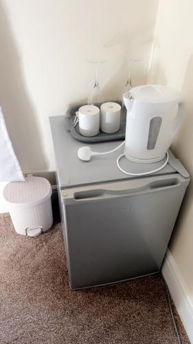 a counter with three cups on top of a refrigerator at Gravesend Guest Retreat in Gravesend
