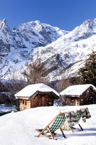 a chair in the snow with mountains in the background at Auberge de La Maison in Courmayeur