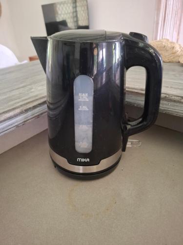 a black coffee pot sitting next to a window at Villa Dolphin in Mtwapa
