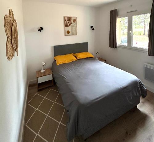 une chambre avec un lit avec des oreillers jaunes dessus dans l'établissement Cala Rossa, Lecci - villa 5 minutes de la très belle plage de Cala Rossa, à Lecci