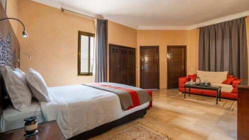 a bedroom with a bed and a living room at Palais Du Desert Hotel & Spa in Erfoud