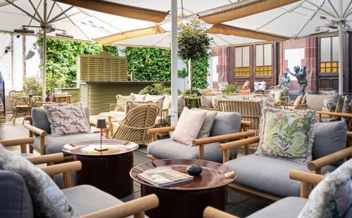a patio with chairs and tables and umbrellas at Brunfels Hotel, in the Unbound Collection by Hyatt in Mainz