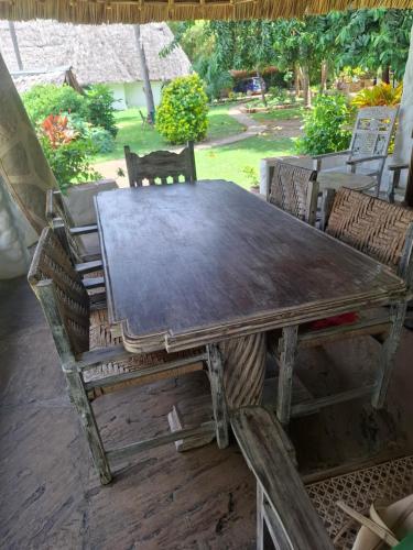 a wooden table and chairs on a patio at Villa Dolphin in Mtwapa