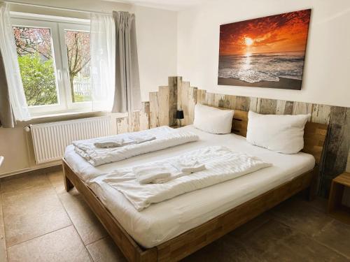 a bedroom with two beds and a large window at Ferienhaus Wiedingharde II in Tating