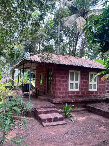 a small red brick house with a porch at Atithi Parinay Homestay in Ratnagiri