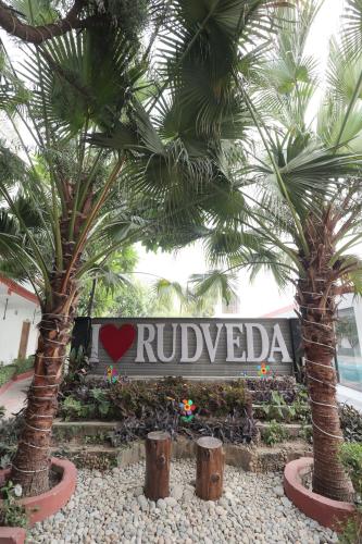 two palm trees in front of a hotel sign at Staybook The Rudveda Resort - Free High Tea near Pool Area in Rāmnagar