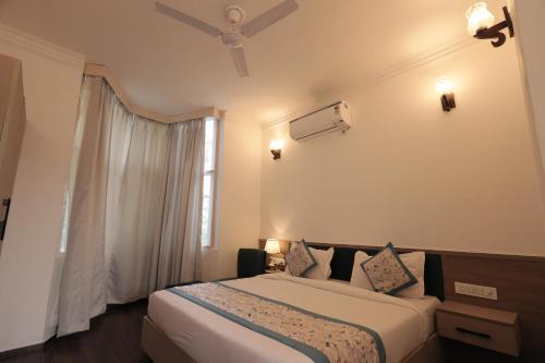 a hotel room with a bed and a window at Staybook The Rudveda Resort - Free High Tea near Pool Area in Rāmnagar