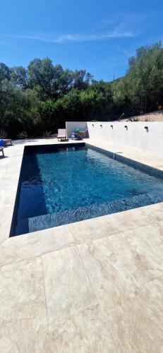 une piscine avec de l'eau bleue dans une cour dans l'établissement Villa moderne avec piscine 4 étoiles, à Sotta
