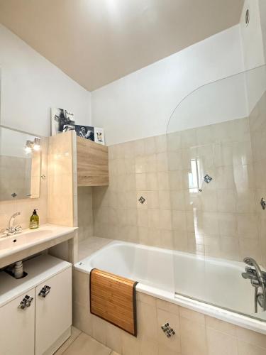 une salle de bain avec une baignoire blanche et un lavabo dans l'établissement Le Nid du Sud, à Arles