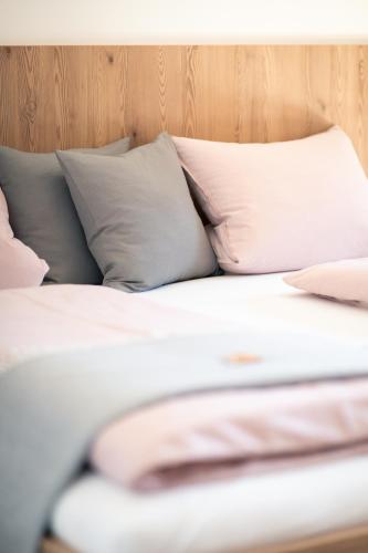 a bed with white sheets and pillows at Nagelehof Apartment Bendelstein in Navis
