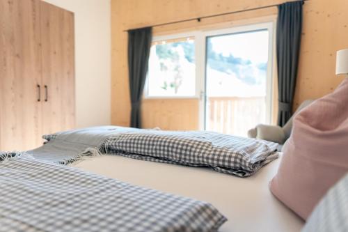 a bedroom with two pillows on a bed with a window at Nagelehof Apartment Bendelstein in Navis