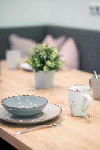 a wooden table with two plates and a bowl and a cup at Nagelehof Apartment Bendelstein in Navis