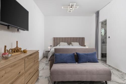 a bedroom with a bed and a couch and a tv at Vila Lux 3 in Rijeka