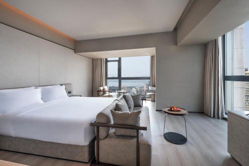 Una habitación de hotel con una cama y una ventana grande. en Crystal Orange Hotel -Hangzhou West Lake Hubin Yintai, en Hangzhou