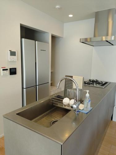 a kitchen with a sink and a refrigerator at SANGA Nature Fujinomiya in Fujinomiya