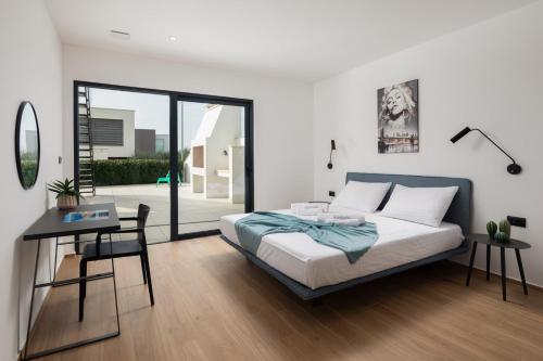a bedroom with a bed and a table and a desk at Villa Old Olive IV - Heated Pool - by Vivi Rent in Vodnjan