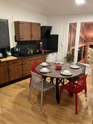 une cuisine avec une table et des chaises dans une cuisine dans l'établissement maison 6 personnes 15 min du circuit, au Mans