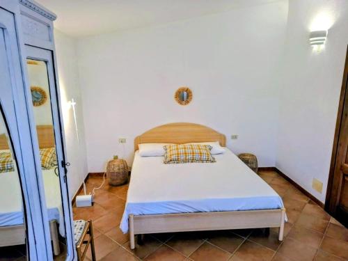 a bedroom with a bed and a mirror at Appartamento in villa Porto Pollo in Porto Pollo