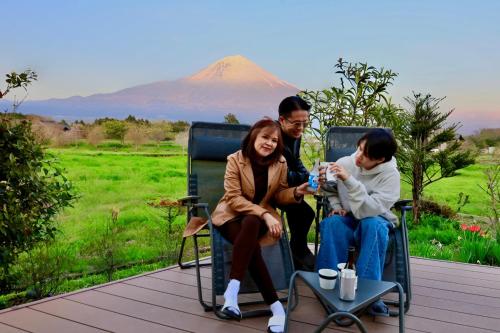 a group of people sitting on a deck with a mountain in the background at SANGA Nature Fujinomiya in Fujinomiya