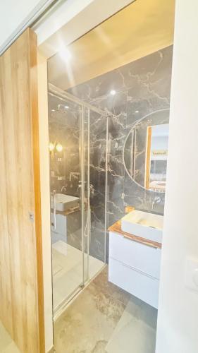une salle de bain avec une douche en verre et un lavabo dans l'établissement L'appart Cassis, à Cassis