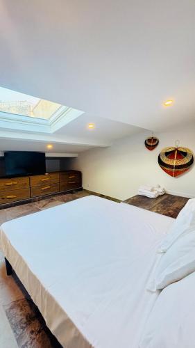 un grand lit blanc dans une chambre avec une fenêtre dans l'établissement L'appart Cassis, à Cassis