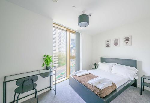 a bedroom with a bed with a desk and a window at Spacious 1 Bedroom Apartment in Central Birmingham in Birmingham