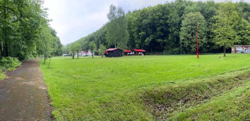 a grassy field with a small building in the distance at ATC Kemp Kajlovec in Hradec nad Moravici