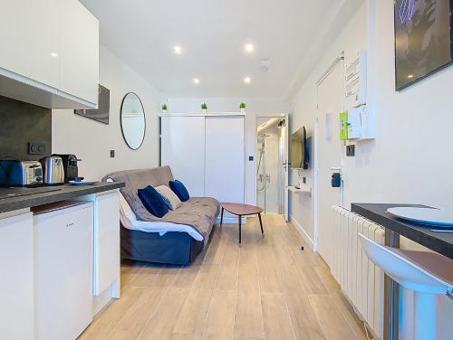 a living room with a couch and a kitchen at Suite Street Art - Appartement central in Argenteuil