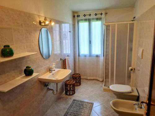 a bathroom with a sink and a toilet and a shower at Appartamento in villa Porto Pollo in Porto Pollo