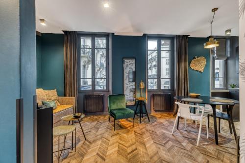 - un salon avec des murs bleus, une table et des chaises dans l'établissement Le Salon - Calme et central, à Aix-les-Bains